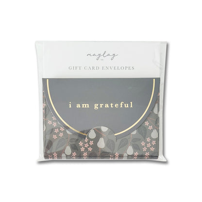 A set of gift card envelopes from Maylay Co., featuring a charming floral and fruit design, complete with a sophisticated matte finish. The Pears 6 Pk Gift Card Envelopes are elegantly embellished with the phrase "I am grateful" and intricate gold foil accents for an added touch of luxury.